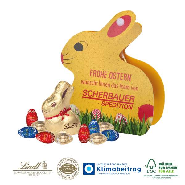 Werbe-Hase mit Goldhase und Schoko-Eier von Lindt auf Graspapier